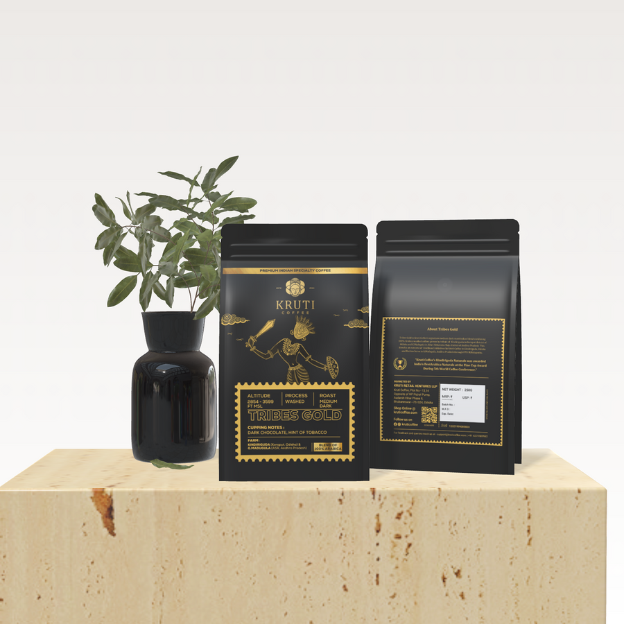 Tribes Gold Coffee Pack on a Beige Color Platform beside a Plant in a Vas 